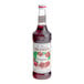 A white labeled Monin bottle of pomegranate syrup.