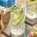 A close-up of a glass of water with a cucumber slice.