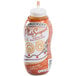 A plastic Smucker's bottle of spiced caramel syrup with a white label.