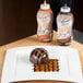 A chocolate dessert on a plate with Smucker's caramel and chocolate syrup drizzled on top.