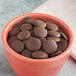 A bowl of Cacao Barry 75% dark chocolate pistoles.