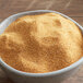 A bowl of yellow powder on a table.