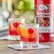 A glass of Master of Mixes Old Fashioned with an orange slice and cherry.