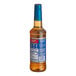 A Torani Sugar-Free Caramel Flavoring Syrup plastic bottle with a blue label.
