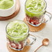 A glass cup with ice and a green liquid made with Jade Leaf Organic Sweetened Matcha Latte Mix.
