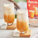 Two glasses of Thaiwala Thai tea on a wooden table with coasters.
