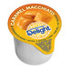 A close up of a case of International Delight Caramel Macchiato Single Serve Non-Dairy Creamer.