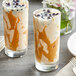 Two glasses of milkshakes made with Fanale peanut butter powder, topped with caramel sauce and blueberries.