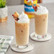 Two glasses of iced coffee with whipped cream and Torani Butter Pecan flavoring syrup.