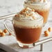 A glass mug of DaVinci Gourmet Toasted Hazelnut flavoring syrup in a brown drink with whipped cream.