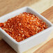 A white square bowl filled with red and white powder.