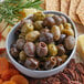 A bowl of Frutto d'Italia Italian olive mix with crackers and cheese.