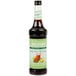 A Monin Mango Tea Concentrate bottle with a green label.
