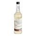 A white Monin bottle of liquid with a label.