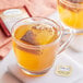 A glass mug of Twinings Orange & Cinnamon Spice tea with a bag in it.