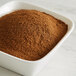 A bowl of brown Regal Ground Cloves powder on a marble counter.