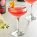 A glass of pink liquid with a DaVinci Gourmet Classic Rose drink in it, garnished with a slice of orange.