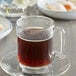 A glass mug of Caffe de Aroma Kona style coffee on a saucer with cookies.