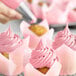 A close up of a cupcake with Chefmaster rose pink frosting.