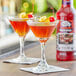 Two glasses of Master of Mixes Manhattan Martini with a cherry.