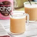 A glass mug filled with brown David Rio Flamingo Vanilla Decaf Sugar-Free Chai tea.