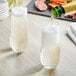 A green Lyre's Classico Non-Alcoholic sparkling wine being poured into a glass on a table.