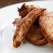 A white plate of grilled chicken seasoned with Regal Cajun spice on a table.