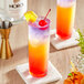 Two colorful NOROI Esprit-de-Mexico non-alcoholic tequila drinks with cherries and a cherry on top.