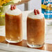 Two glasses of brown drinks topped with whipped cream and almonds using Torani Sugar-Free Almond Flavoring Syrup.