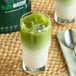 A glass of green Tenzo matcha tea on a white background.