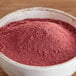 A bowl of red Regal Beetroot Powder on a wooden table.