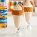 Two glasses of ice cream with whipped cream and caramel on top with Torani Sugar-Free Pumpkin Pie syrup.