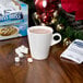 A white mug of Swiss Miss hot chocolate with marshmallows on a table.