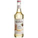 A bottle of Monin Premium White Chocolate flavoring syrup with a white label.