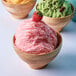 A group of bowls of snow ice with different flavors including pink and green.