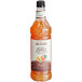 A close up of a bottle of Monin Premium Zero Calorie Natural Peach Flavoring syrup.