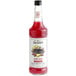 A bottle of Monin's cherry smash cocktail mix with red liquid inside.