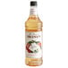 A case of 4 bottles of Monin Lychee Flavoring Syrup with a label.