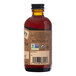 A close-up of a Nielsen-Massey Pure Coffee Extract bottle filled with brown liquid.