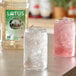 A clear glass jar with Lotus Plant Power White Lotus Energy Concentrate over ice.