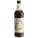 A close up of a Monin Wildberry Syrup bottle with a label.