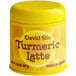 A yellow David Rio Turmeric Latte Mix container with a yellow lid on a counter.