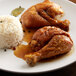 A plate of food with rice and chicken seasoned with Regal Adobo seasoning on a table.