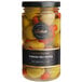 A jar of Belosa Turkish olives with red peppers on a yellow surface.
