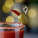 A drink with a Belosa Turkish red pepper stuffed green olive on top.