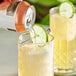 A person pouring a Goslings Peach Ginger Beer into a glass with ice and a lime