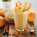 A glass of Smartfruit Perfect Peach Puree with whipped cream and cookies on a table.