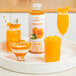 A table with a Smartfruit Perfect Peach Puree drink and other drinks on it.