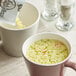 A white cup of Lipton instant chicken noodle soup with noodles in it.