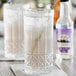 Two glasses of water with ice and lavender next to a bottle of Fee Brothers Lavender Water.